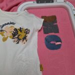 Roze trui waar al twee letters zichtbaar zijn. De M en de O
