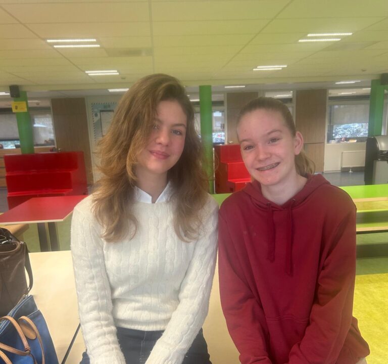 Jackie en Eveline zitten naast elkaar en kijken in de camera